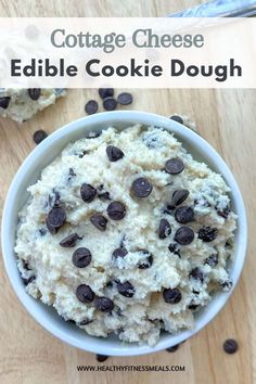 a bowl filled with cookie dough on top of a wooden table next to chocolate chips