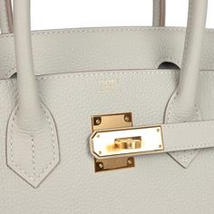 This Birkin is in Gris Perle togo leather with gold hardware and has tonal stitching, front flap, two straps with center toggle closure, clochette with lock and two keys, and double rolled handles.The interior is lined with Gris Perle chevre leather and has a zip pocket with an Hermes engraved pull and a pocket on opposite side.Collection: UOrigin: FranceCondition: Pre-owned; Mint - This bag retains its shape. The exterior leather is clean with no signs of wear or use. There's plastic on the har Timeless Bags With Metal Hardware And Togo Leather, Timeless Togo Leather Bag With Metal Hardware, Gold Epsom Leather Bag With Lock, Designer Togo Leather Bag With Metal Hardware, Timeless Epsom Leather Bag With Metal Hardware, Elegant Togo Leather Bags With Metal Hardware, Timeless Togo Leather Bag With Gold-tone Hardware, Togo Leather Bags With Metal Hardware For Everyday Use, Everyday Togo Leather Bag With Metal Hardware