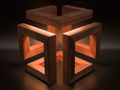 an illuminated wooden cube on a dark surface with light coming from the top and bottom