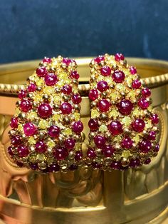 An impressive pair of earrings done in deep 18K yellow gold and set with 3.81cttw in fancy vivid yellow diamonds ranging Si2-I2 clarity as well as 11.12cttw in bright red cabochon rubies (all weights are stamped and exact) . A beautiful pair of earrings that look like no other. They have posts with oversized pushbacks. Dimensions/Weight: Earrings 1.25" by .80" and weigh 27.2g. Condition: All stones are secure and in perfectly wearable condition. E-AHHJ Luxury Yellow Multi-stone Jewelry, Exquisite Multi-stone Yellow Gold Earrings, Exquisite Yellow Gold Multi-stone Earrings, Luxury Ruby Earrings For Evening, Yellow Multi-stone Fine Jewelry, Exquisite Yellow Gold Clip-on Earrings, Exquisite Gold Multi-stone Earrings, Exquisite Multi-stone Gold Earrings, Luxury Gemstone Hoop Earrings