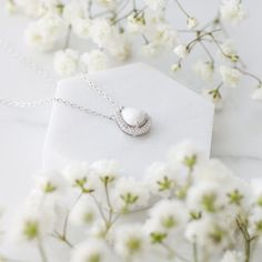 The meaning of "Halo Au Lait" is "Halo with Milk" in French, reflecting the essence of the necklace. The drop-shaped stone is expertly crafted to resemble a drop of milk, capturing the sacrifice of motherhood. Its unique shape also adds deep symbolism to the necklace, reminding us of the life-giving nature of breastmilk. Delicate White Gold Teardrop Pendant Necklace, White Gold Teardrop Pendant Necklace With Gemstone, Silver Teardrop Pendant Birthstone Necklace, Anniversary Pearl Teardrop Pendant Necklace, Diamond White Pear-shaped Gemstone Necklace, Minimalist Diamond White Teardrop Pendant Necklace, Anniversary Jewelry With Natural Stones In Teardrop Pendant, White Teardrop Jewelry As A Gift For Her, Anniversary Teardrop Pearl Pendant Necklace