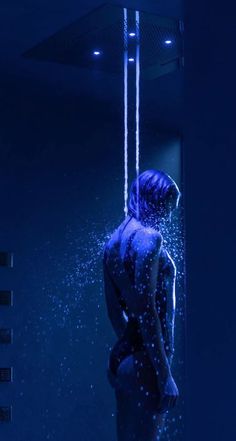 a woman is standing in the shower with her back turned to the camera and water droplets all around her