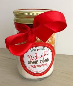 a glass jar filled with some kind of food and a red ribbon tied around it