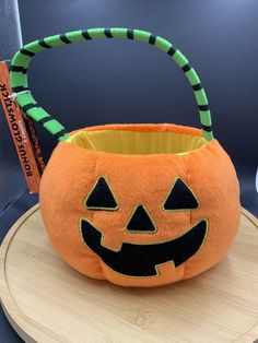 an orange pumpkin shaped basket sitting on top of a table