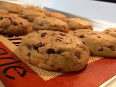 chocolate chip cookies sitting on top of a red napkin next to a pile of other cookies