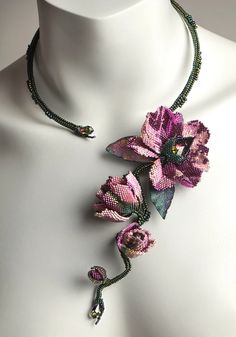 a necklace with flowers and beads on a mannequin