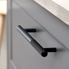 two black handles on a gray cabinet