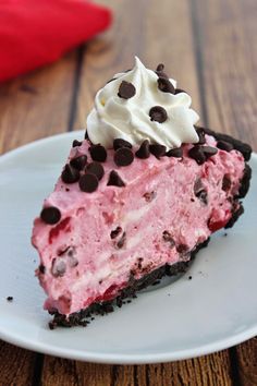 a piece of ice cream pie with chocolate chips and a cherry on the plate next to it