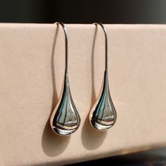 [Details] ✧ Material > sterling silver 92.5% ✧ Color > silver ✧ Size > 8mm(w) x 26mm(h) These beautifully simple Sterling Silver liquid  Drop Earrings have a silver liquid metal effect giving them the fresh flowing appearance of a raindrop. It's contemporary design silver teardrop earrings are simply made to wear with an easy, no fuss fixed hook drop setting. The polished finish and silver liquid metal effect make the earrings appear like recently formed drops of  rain slowly moving over a leaf. Everyday Teardrop Jewelry With Shiny Finish, White Gold Teardrop Jewelry With Shiny Finish, White Gold Teardrop Earrings With Polished Finish, Modern Nickel-free Drop Jewelry, Drop Shaped Jewelry With Shiny Finish For Gifts, Modern Teardrop Earrings For Anniversary, White Gold Teardrop Earrings With Shiny Finish, Minimalist Long Drop Earrings With Polished Finish, Classic Drop Earrings With Polished Finish For Gift