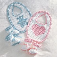 two crocheted baby bibs and booties on a white sheet