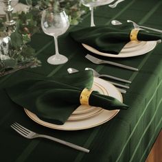 the table is set with green napkins and place settings