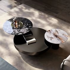 a modern coffee table with marble top and metal base, sitting on the floor next to a couch