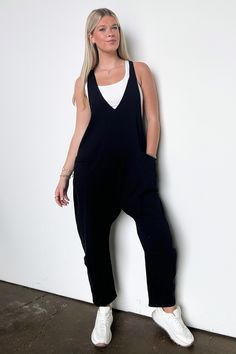 Details: Unwind and look effortlessly stylish with our Relaxed Fit V-Neck Jumpsuit. Made from a soft, solid knit fabric, this baggy jumpsuit offers a casual loose fit for all-day comfort. The sleeveless design, deep V-neck, and raw edge detail add unique touches, while the side pockets provide convenience. Dress it up or dress it down, this jumpsuit is perfect for any occasion!- Pockets - Relaxed fit - V-neck Content: 95% Cotton,5% SpandexSize + Fit: Model is 5'9" (mocha) and wearing a Small - M Casual V-neck Jumpsuit With Relaxed Fit, Solid Color V-neck Jumpsuits And Rompers For Leisure, Casual Overall Jumpsuits And Rompers For Loungewear, Casual Solid Color Overalls Romper, Casual V-neck Jumpsuits And Rompers In Solid Color, Black Lounging Jumpsuits And Rompers For Spring, Solid Color V-neck Jumpsuit For Loungewear, Black Relaxed Fit Jumpsuits And Rompers For Loungewear, Solid Color Relaxed Fit Jumpsuit For Leisure