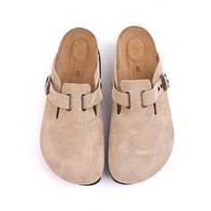 a pair of beige shoes with buckles on the front and back straps, against a white background