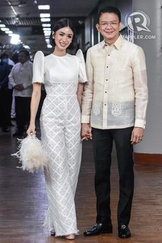 a man and woman standing next to each other on a hard wood flooring area