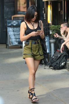 She epitomizes cool in a black tank, belted army green shorts, lace-up sandals, fringe bag, and a leather necklace that we need, like, now. - MarieClaire.com Vanessa Hudgens Outfits, Green Shorts Outfit, Estilo Vanessa Hudgens, Vanessa Hudgens Style, Army Green Shorts, Estilo Hippie, Look Short, Fall Jacket, Jennifer Garner