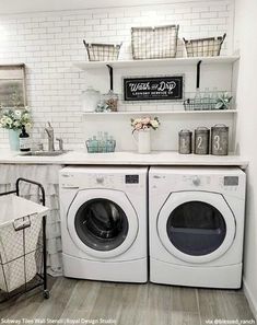 a washer and dryer sitting in a room next to a shelf with baskets on it