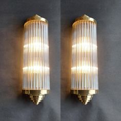 pair of wall lights with pleated glass shades and brass fittings on each side