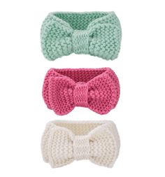 three crocheted bow ties are shown in three different colors, one white and one pink