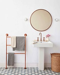 a bathroom with a sink, mirror and towel rack