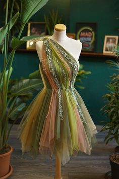 a mannequin is dressed up in a green and pink dress with sequins