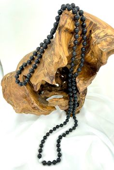 "This handcrafted, hand knotted, mala style necklace features lava, matte black onyx and white jade. Black onyx promotes strength, stamina, and constancy along with the lava which gives inspiration, creativity, and peace.  Jade is an amulet of good luck.  Jade aids in emotional and spiritual healing as well as promotes courage, wisdom, stability, longevity, and fertility. This necklace has a high quality S-Lon core.  Necklace is 46.5\" (see photos). Please Note: 1. Colors may vary slightly due t Black Necklaces With Natural Stones For Meditation, Onyx Bead Necklaces For Meditation, Onyx Necklace With Black Beads For Meditation, Black Gemstone Beads Necklace For Meditation, Black Gemstone Beads Mala For Healing, Black Necklaces With 8mm Beads For Meditation, Black Mala With 8mm Beads For Healing, Hand-strung Black Mala For Meditation, Black Hand-strung Mala For Meditation