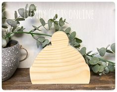 a wooden cutting board sitting on top of a table next to a potted plant