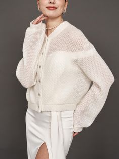 a woman posing for the camera wearing a white sweater and skirt