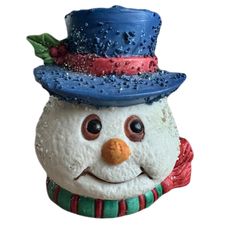 a close up of a snowman with a hat and scarf on it's head