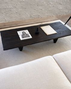 a coffee table with an open book on it and a pen resting on top of it