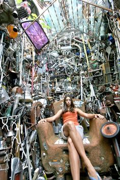 a woman sitting on top of a chair covered in lots of junk