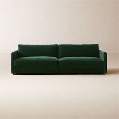 a green couch sitting on top of a white floor