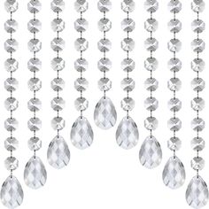 a group of crystal beads hanging from the side of a white wall with diamonds on it