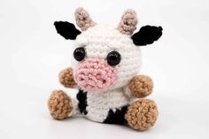 a crocheted stuffed cow with black and white stripes on it's face