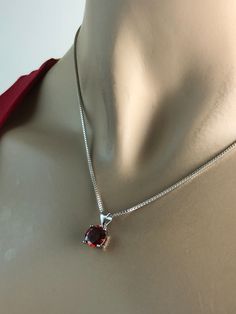 "Sterling Silver Garnet Necklace, Garnet Cubic Zirconia Pendant Necklace NECKLACE FEATURES: Metal: All components are made from solid .925 Sterling Silver Model is wearing 16\" in length solid .925 Sterling Silver Chain Length available: 16\", 18\" or 20\" Stone: Garnet CZ THE Garnet CZ pendant measures 8mm in height Your Garnet Necklace will arrive in a gift box, beautifully wrapped and ready for gifting Please send me a convo if you have any questions before placing your order. Please also vie Classic Birthday Jewelry With Prong Setting, Elegant Red Necklace For Birthday Gift, Red Necklace With Prong Setting As Gift, Red Round Pendant Birthstone Necklace For Formal Occasions, Red Round Stone Necklaces For Anniversary, Formal Red Birthstone Necklace With Round Pendant, Classic Red Birthstone Necklace As Gift, Classic Red Birthstone Necklace For Gift, Formal Red Round Pendant Birthstone Necklace