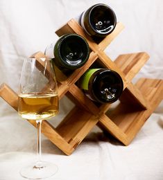 three bottles of wine and two glasses on a wooden stand