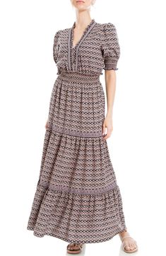 Smocking defines the waist of this maxi dress designed in a tiered silhouette and puff sleeves. 54 1/2" length V-neck Short sleeves Unlined 96% polyester, 4% spandex Machine wash, line dry Imported Model stats: 5'10" height, 32" bust, 25" waist, 36" hip. Model is wearing size Small. Bohemian Maxi Dress With Puff Sleeves And Smocked Back, Black Bohemian Tiered Maxi Dress, Black Tiered Bohemian Maxi Dress, Maxi Dress Designs, Tiered Maxi Dress, Floral Short, Max Studio, Puff Sleeves, Black Floral