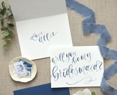 wedding stationery and envelopes with calligraphy on linen, blue ribbon and flowers