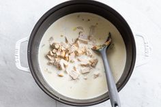 the food is being cooked in the pot on the stove top, with a spoon