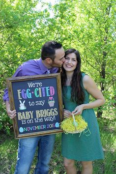 a man and woman posing for a photo holding a sign that says we're egg city to say baby eggs on the way