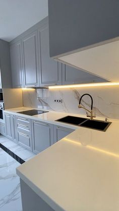 a kitchen with marble counter tops and white cupboards on the walls, along with an island