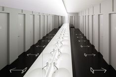 rows of sinks in a long room with white walls