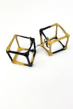 pair of black and gold geometric earrings on white background