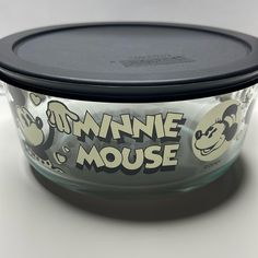 an empty glass bowl with mickey mouse designs on it's lid and the words minnie mouse written in large letters