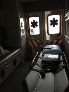 an empty hospital room with luggage on the bed