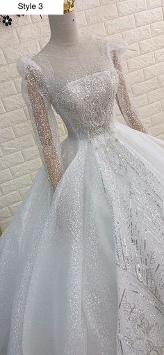 a white wedding dress with long sleeves and sequins on the bouncy