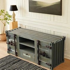 a tv stand made out of shipping containers in a living room with a rug on the floor