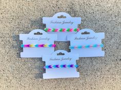 four colorful bracelets with name tags on them