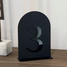 a black metal number 3 on a wooden table