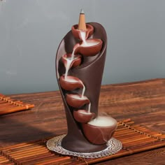 a chocolate sculpture with a pencil sticking out of it's center on a wooden table